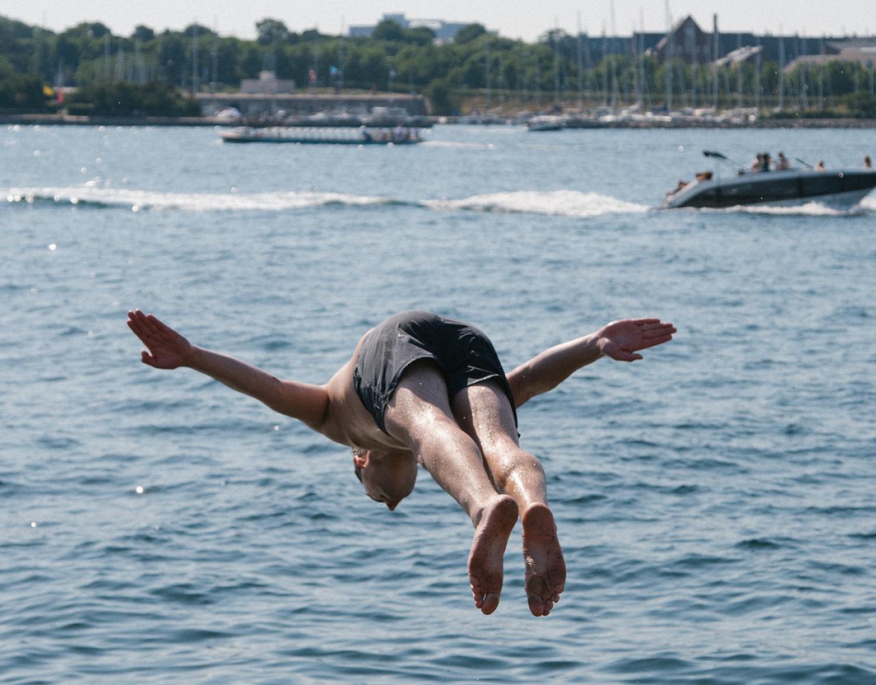 mand hopper på hovedet i havnen ved Refshaleøen